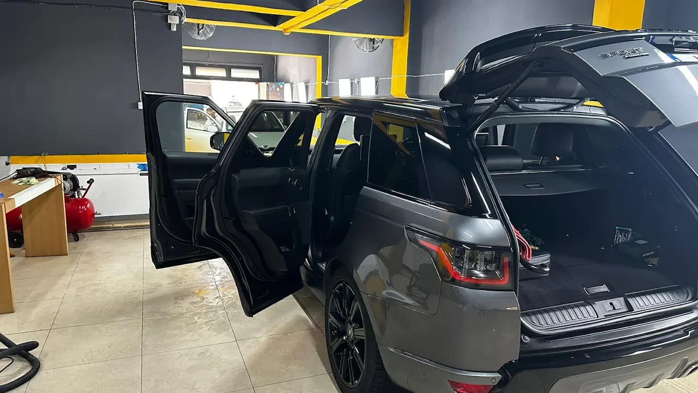 A grey Range Rover Sport with its tailgate and doors open, mid interior detail